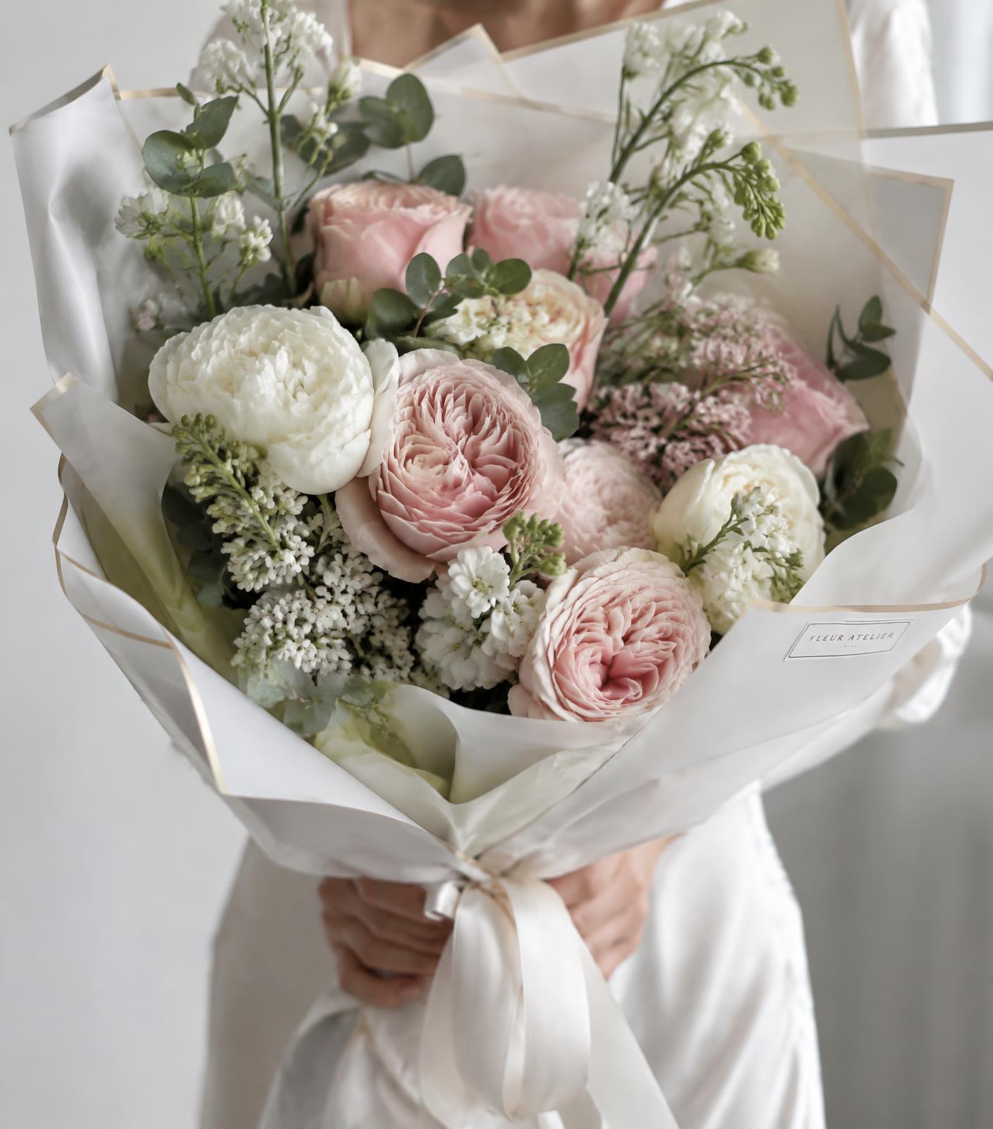 Buquê de flores frescas em tons de rosa-blush e branco sendo preparado pela Enflore-se
